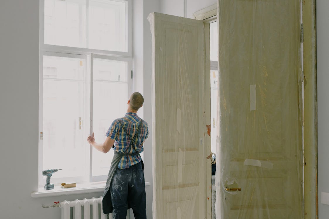 Handyman installing window in house