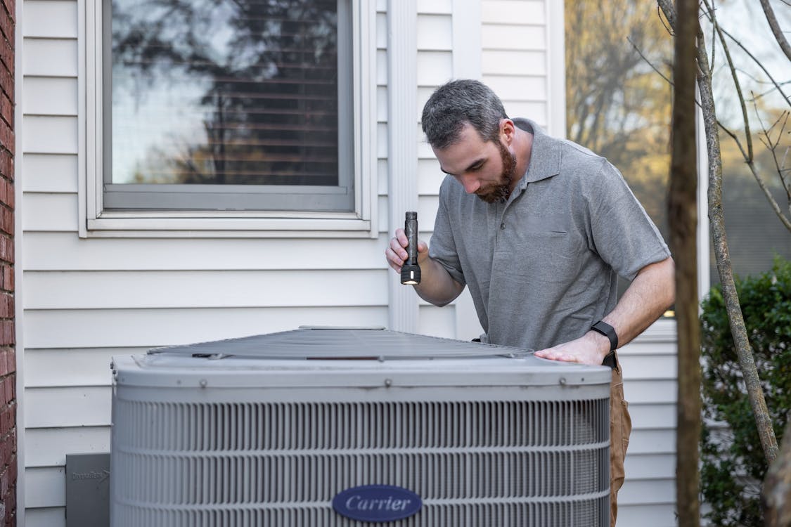 HVAC technician inspecting outdoor unit